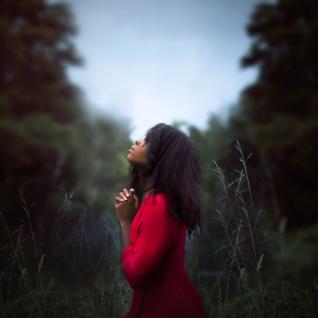 Black lady praying outdoors